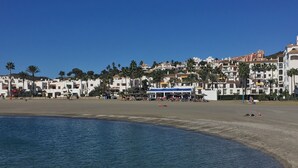 A coastal town with white buildings, a sandy beach, and a calm sea. - Residencial Duquesa 2239 Sea & Sun (Manilva)