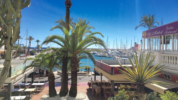 A marina with boats, a restaurant named 'Taj Mahal Restaurant', and palm trees. - Residencial Duquesa 2239 Sea & Sun (Manilva)