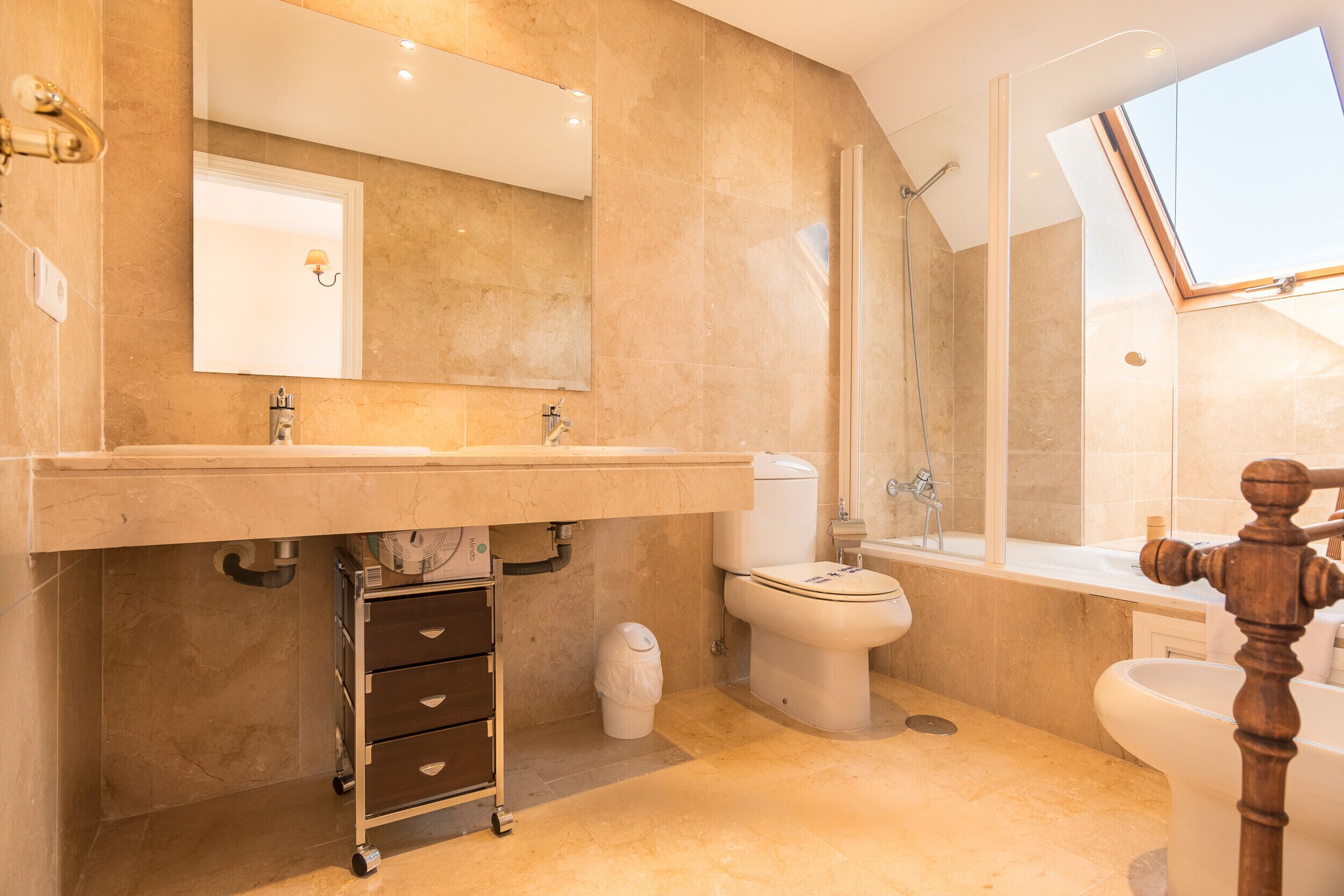 Un baño moderno con un espejo grande, una bañera y una ducha.
