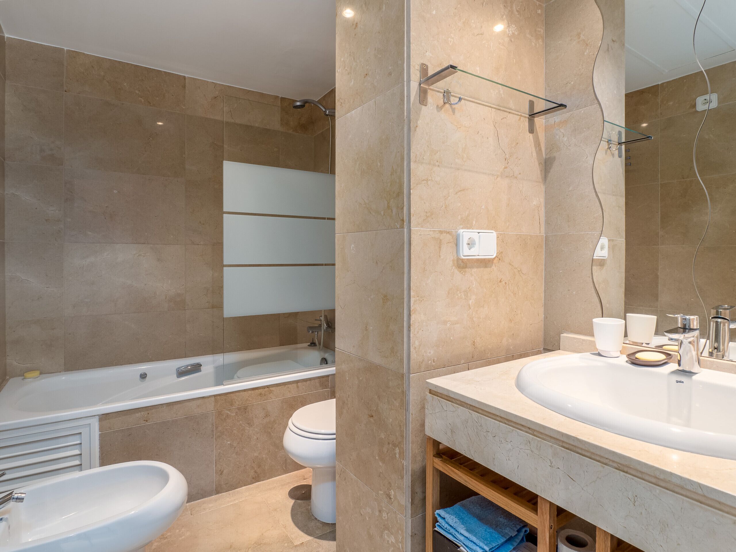 A modern bathroom with a bathtub, a sink, and a toilet.