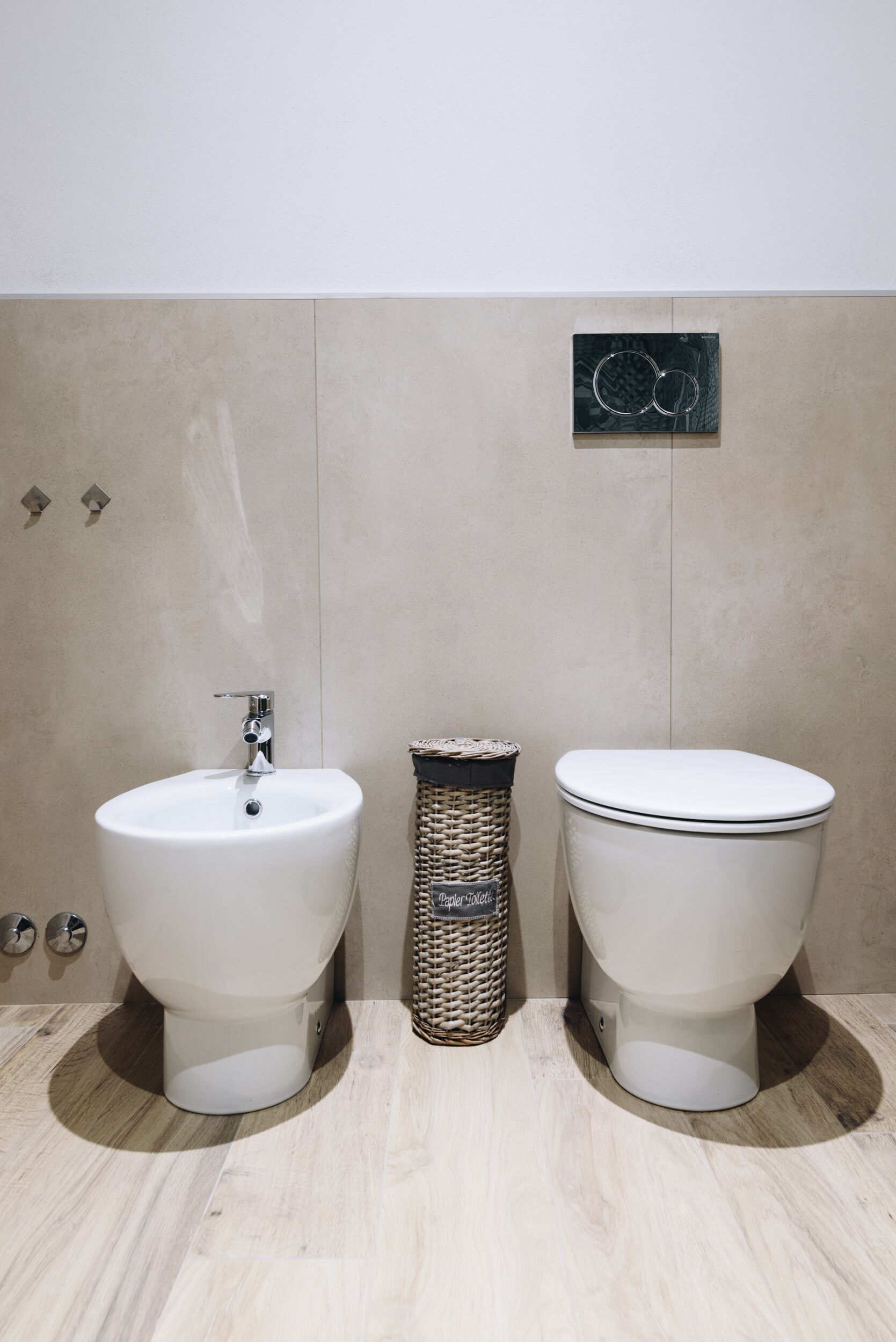 Un baño moderno con lavamanos, inodoro y un adorno en la pared.