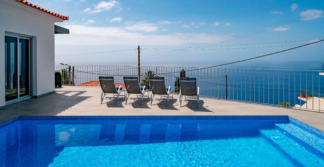 Una piscina al aire libre, sombrillas, tumbonas