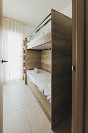 A bunk bed with a wooden frame and a white mattress. - Kikopark (Oliva)