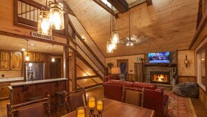 A rustic interior with a dining area, kitchen, and living room. - Mountain Views | 4 King Bedroom Luxury Cabin | Hot Tub + Fire Pit (Blue Ridge)