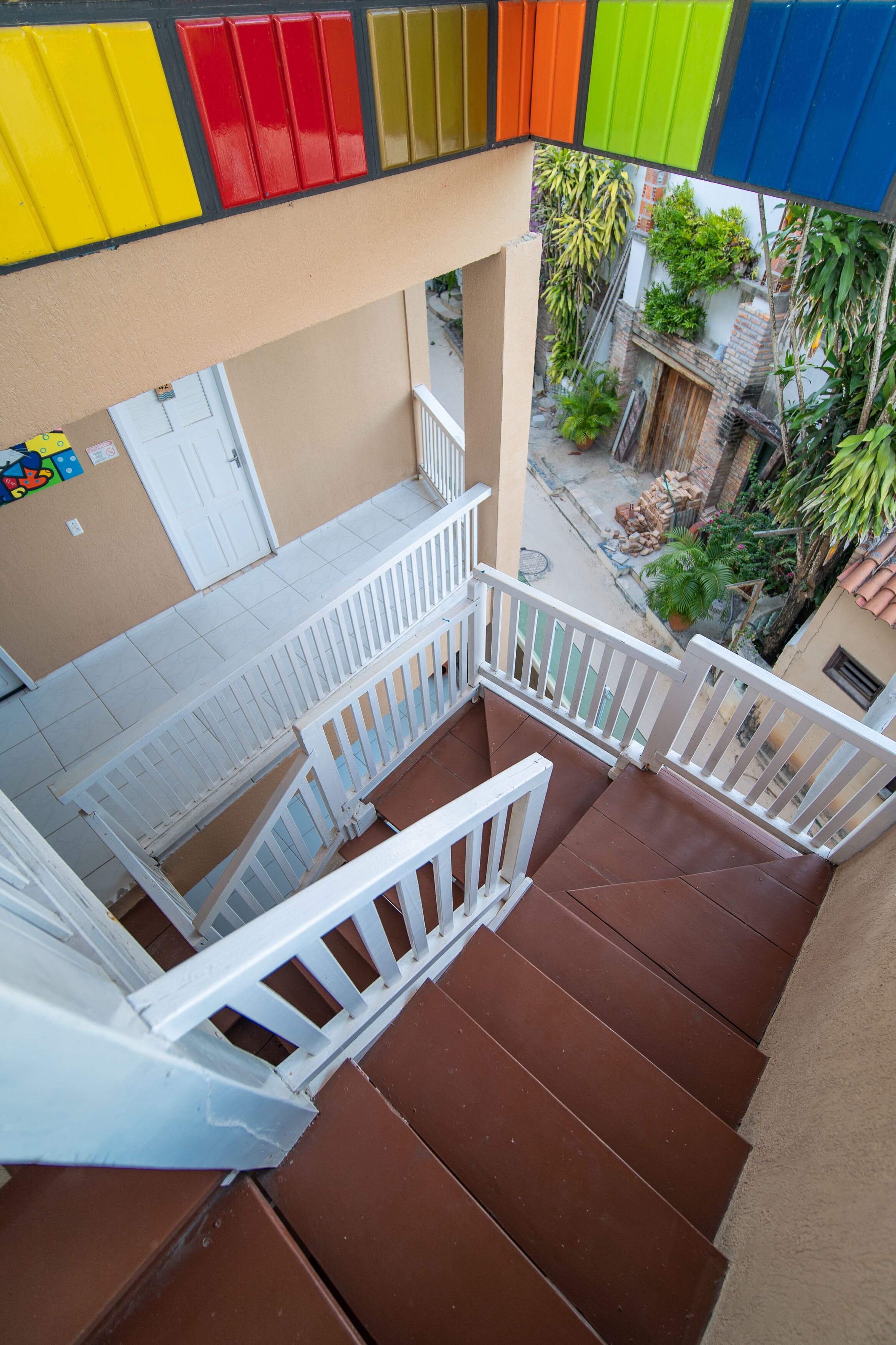Un immeuble à plusieurs étages, doté d’un escalier et d’une rambarde blanche.