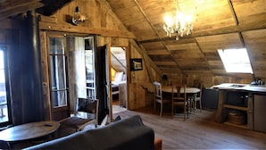 Un intérieur rustique en bois, comprenant un coin repas, une cuisine et un espace salon confortable.