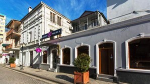 Un hotel amb una façana clàssica, un balcó i un rètol que indica que és un hotel.