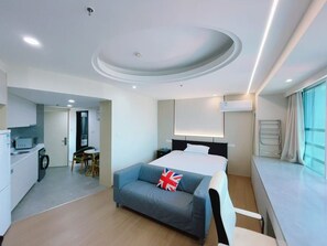 A modern hotel room with a bed, a sofa, a small kitchen area, and a bathroom. - Bs Service Apartment Hotel (Shanghai)