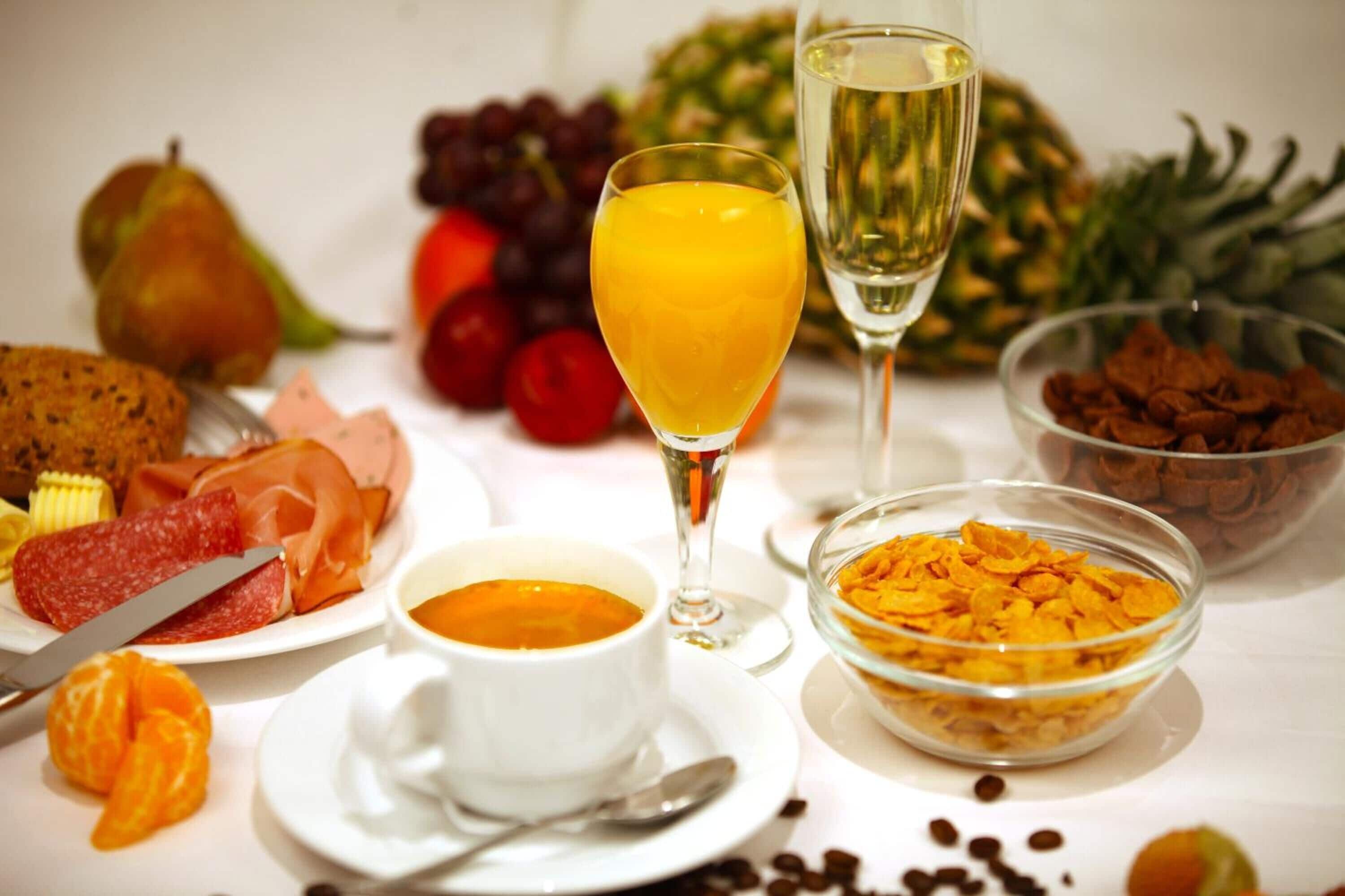 Une table dressée pour le petit-déjeuner, avec divers aliments et boissons.