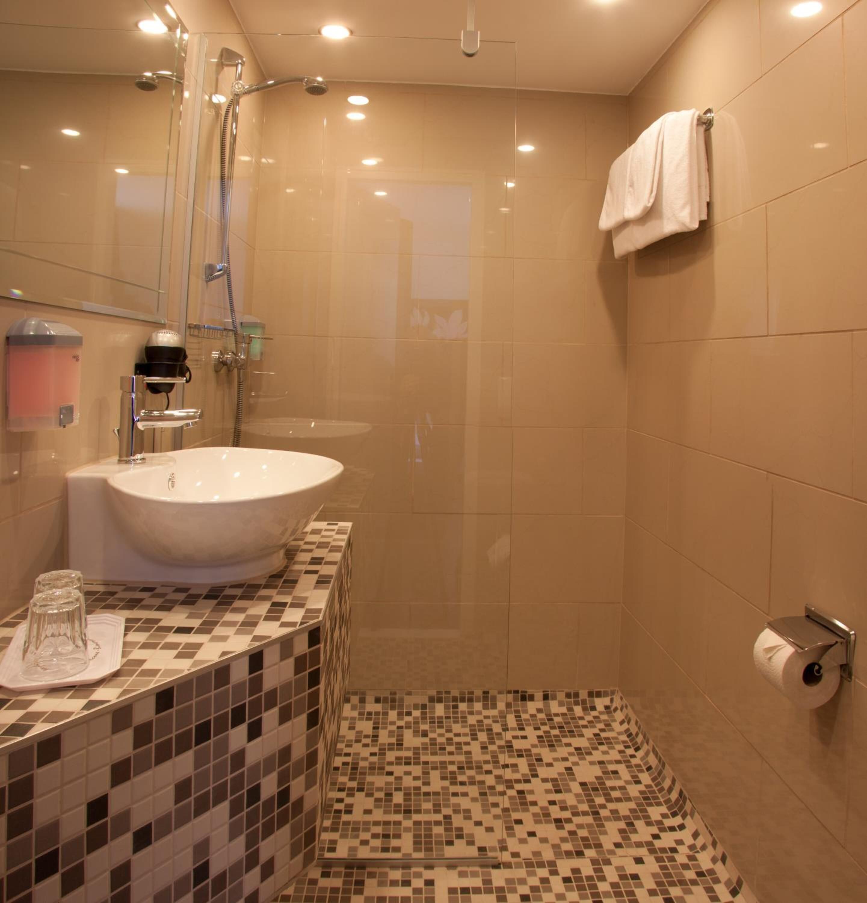 Ein modernes Badezimmer mit einem großen Waschbecken, einer Dusche und einem WC.