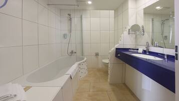 Ein modernes Badezimmer mit Badewanne, Waschbecken und Dusche.