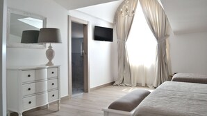 A bedroom with a bed, a TV, a dresser, and a window with curtains. - B&B Cloud (Santa Maria Capua Vetere)