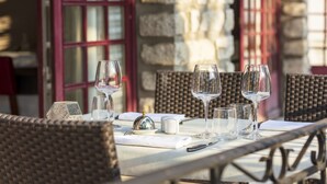 A table set for dining with wine glasses, a salt and pepper shaker, and a silver cloche. - Hotel La Chaumiere (Quillan)
