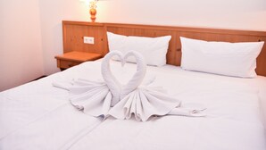 A hotel room with a neatly made bed, a wooden headboard, and a bedside lamp. - Aparthotel Sonnenburg (Schluchsee)