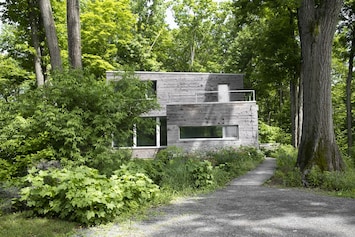 the passive haus sits on a ledge amongst 100 year old oaks