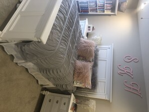 Cozy retreat with a neatly made bed, wardrobe, and bookshelf.