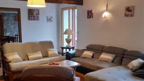 Una sala de estar acogedora con un sofá, un sillón y una mesita.