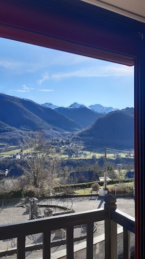 Ein Balkon mit Blick auf ein Tal, Berge und einen klaren Himmel.