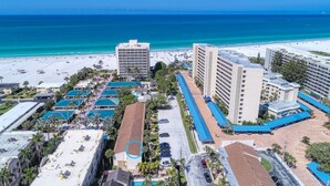 Ein Resort mit Blick auf den Strand, mehreren Gebäuden und einem Parkplatz.