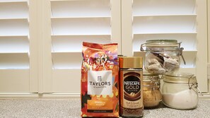 A bag of Taylors of Harrogate coffee, a Nescafe Gold Blend coffee jar, and a jar of creamer on a countertop. - Grand Edinburgh Castlehill Apartment (Edinburgh)