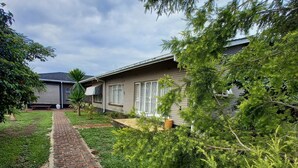 A residential property with a paved pathway leading to a house with a garage. - Las Palmas Guest House (Harare)