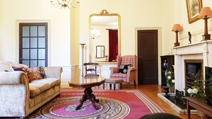 A living room with a sofa, armchair, table, and a fireplace. - Classy Historic Edinburgh Apartment (Edinburgh)