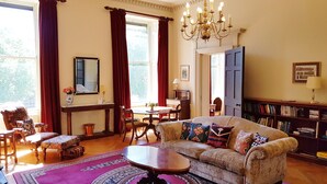 A cozy living room with a sofa, armchairs, a coffee table, and a bookshelf. - Classy Historic Edinburgh Apartment (Edinburgh)