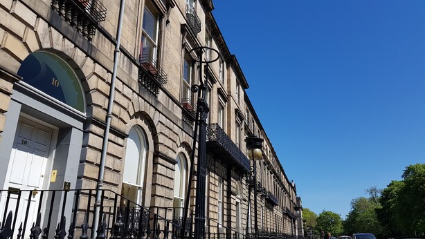 A historic building with arched windows, a prominent number '10' door, and black wrought iron balconies. - Classy Historic Edinburgh Apartment (Edinburgh)