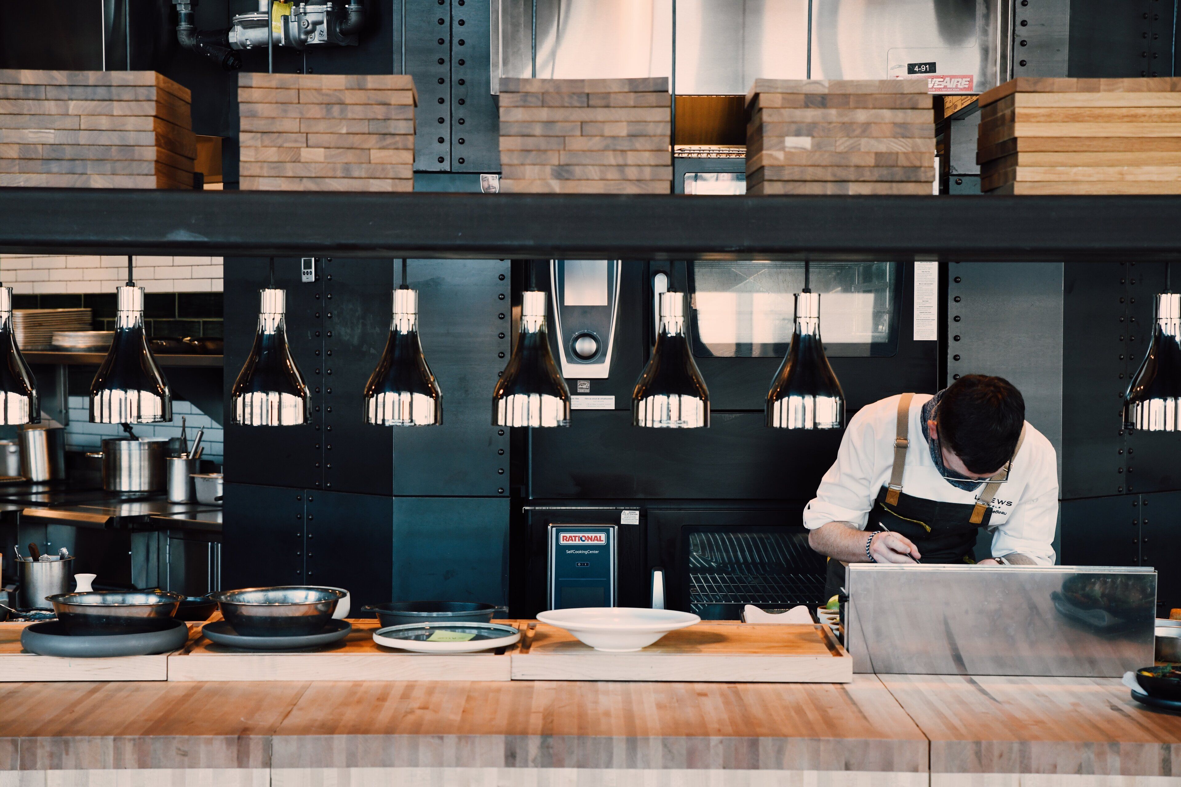 A chef working at a counter with various kitchen utensils and equipment.