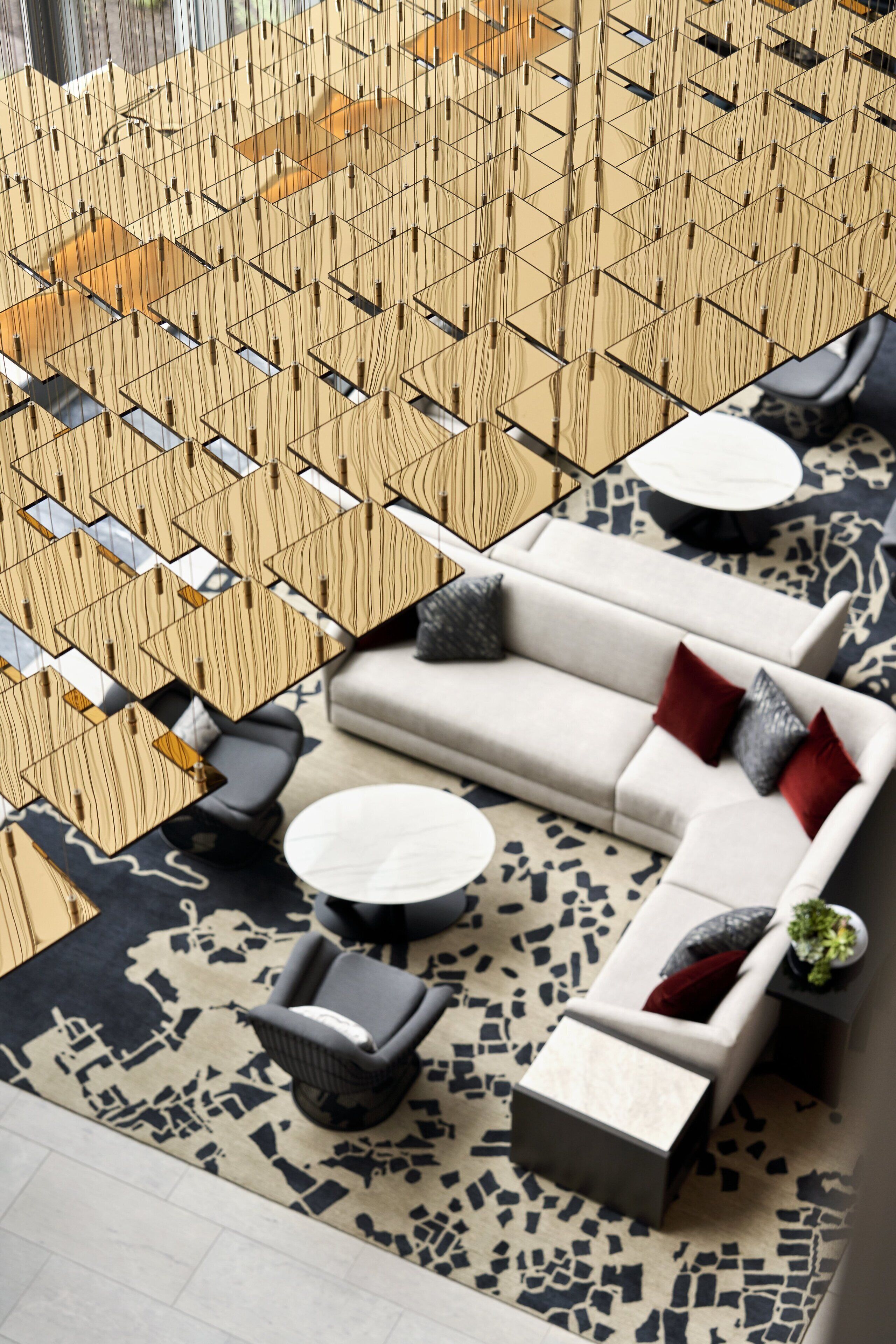 A modern lounge area with a geometric patterned wall, a sofa set, and a coffee table.