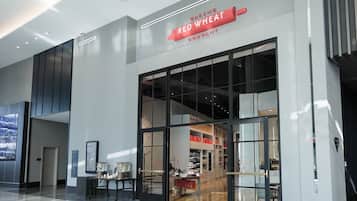 A modern building with a large glass entrance and a sign reading "Baking Red Wheat Company".