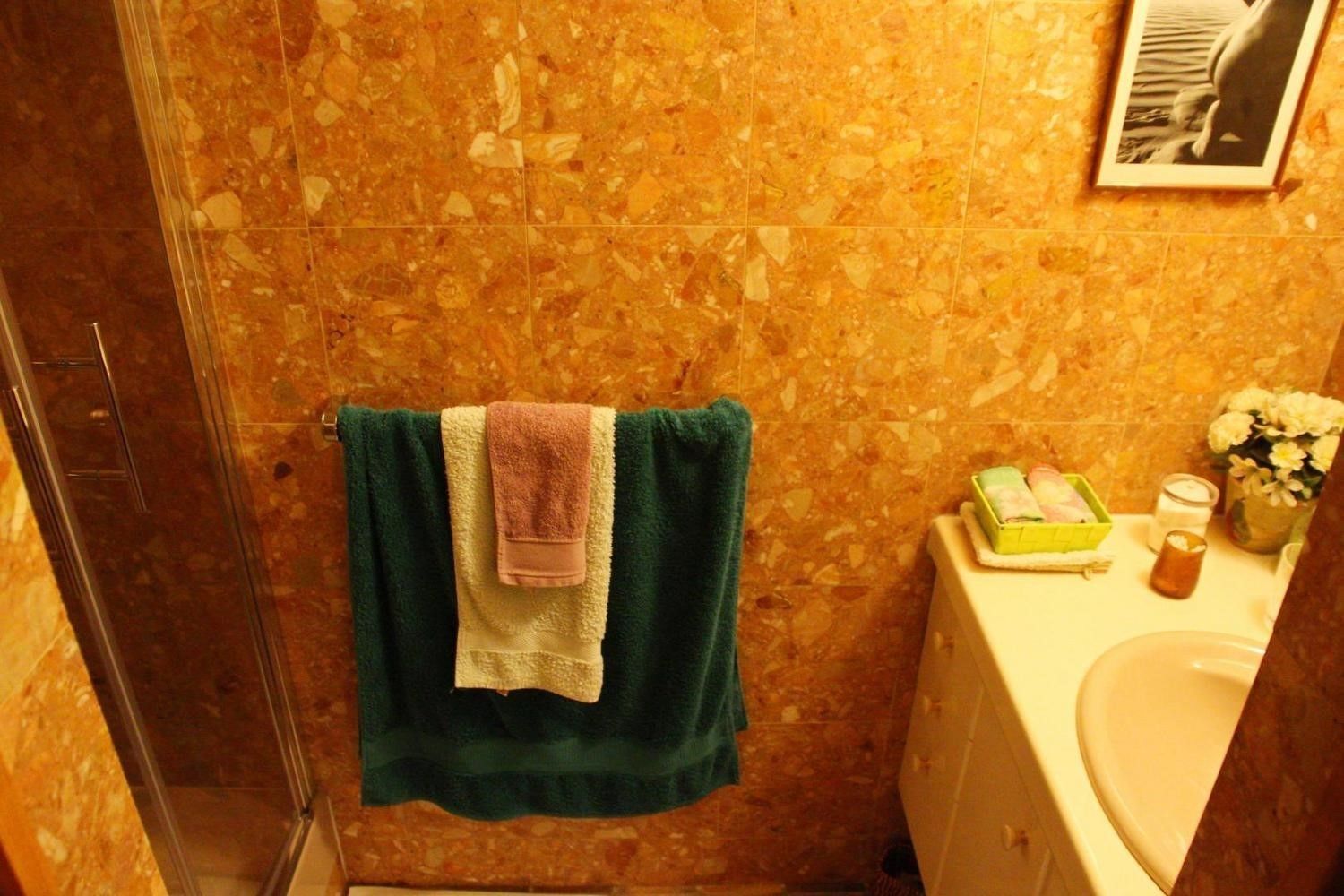 Une salle de bain avec une douche, un lavabo et des articles de toilette.