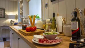 A kitchen counter with various food items and a bottle of wine. - Converted Luxury Barn - The Potting Shed - Grade II listed (Cirencester)