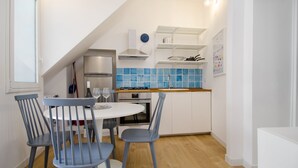 Una cocina moderna con armarios blancos, un respuesto de azulejos azules y una encimera de madera.