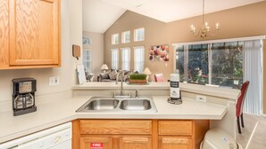 A modern kitchen with wooden cabinets, a double sink, and a built-in dishwasher.