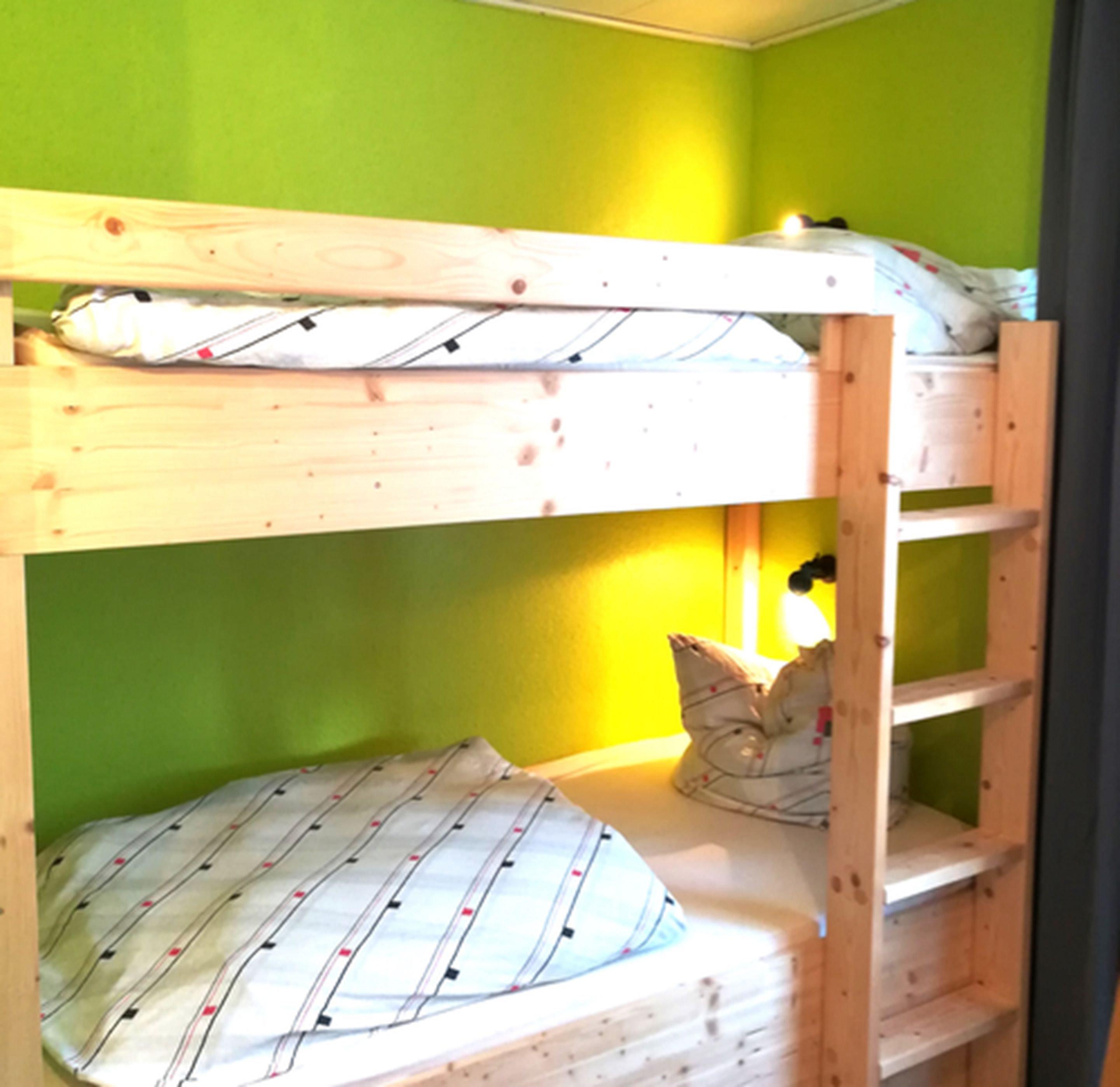 A bunk bed with a pillow and a blanket.