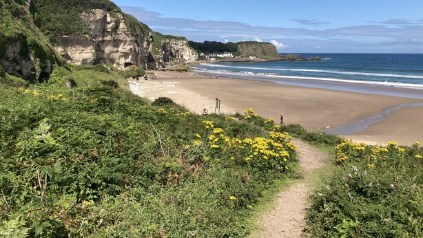 A coastal path leading to a beach with cliffs and a clear sky. - Porthole Cottage, Bushmills -
 a place to unwind and relax. (Dunseverick)