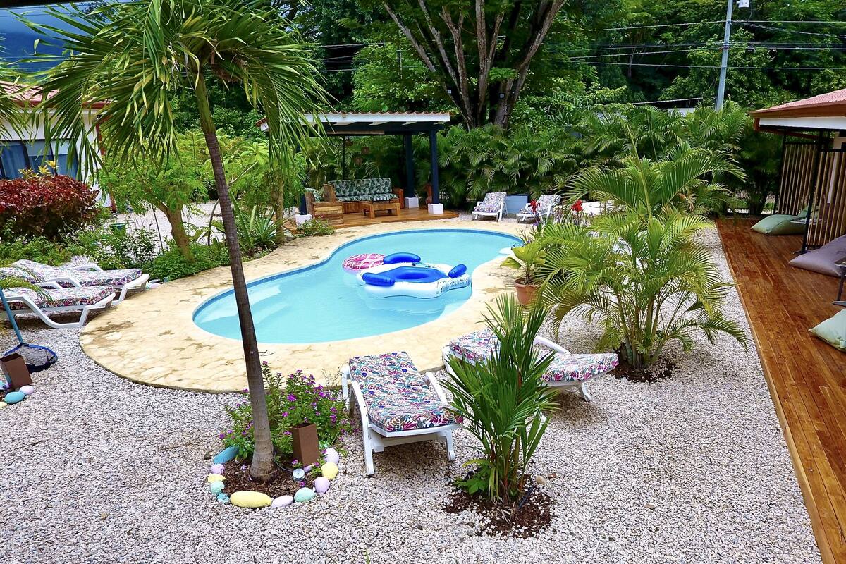 Un jardin avec une piscine, des chaises longues et une terrasse en bois.