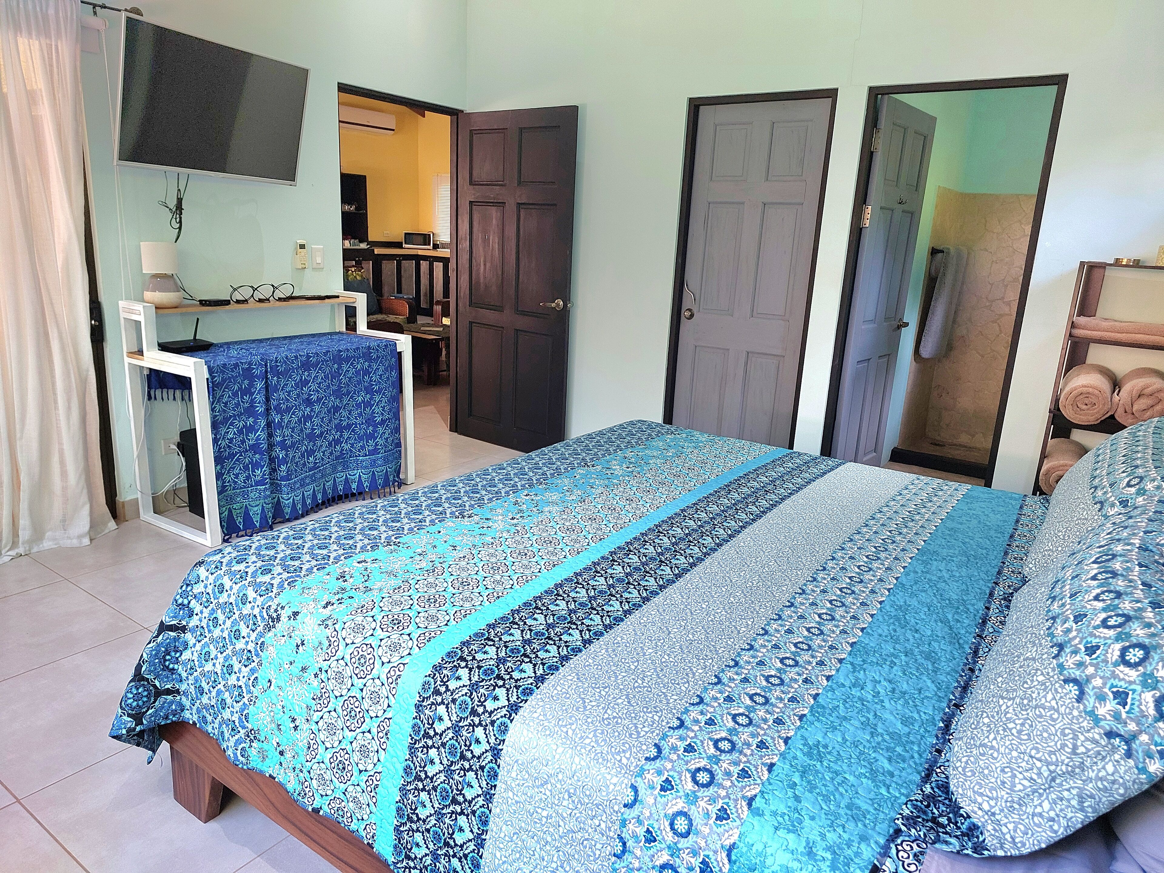 A bedroom with a bed, a desk, and a wardrobe.