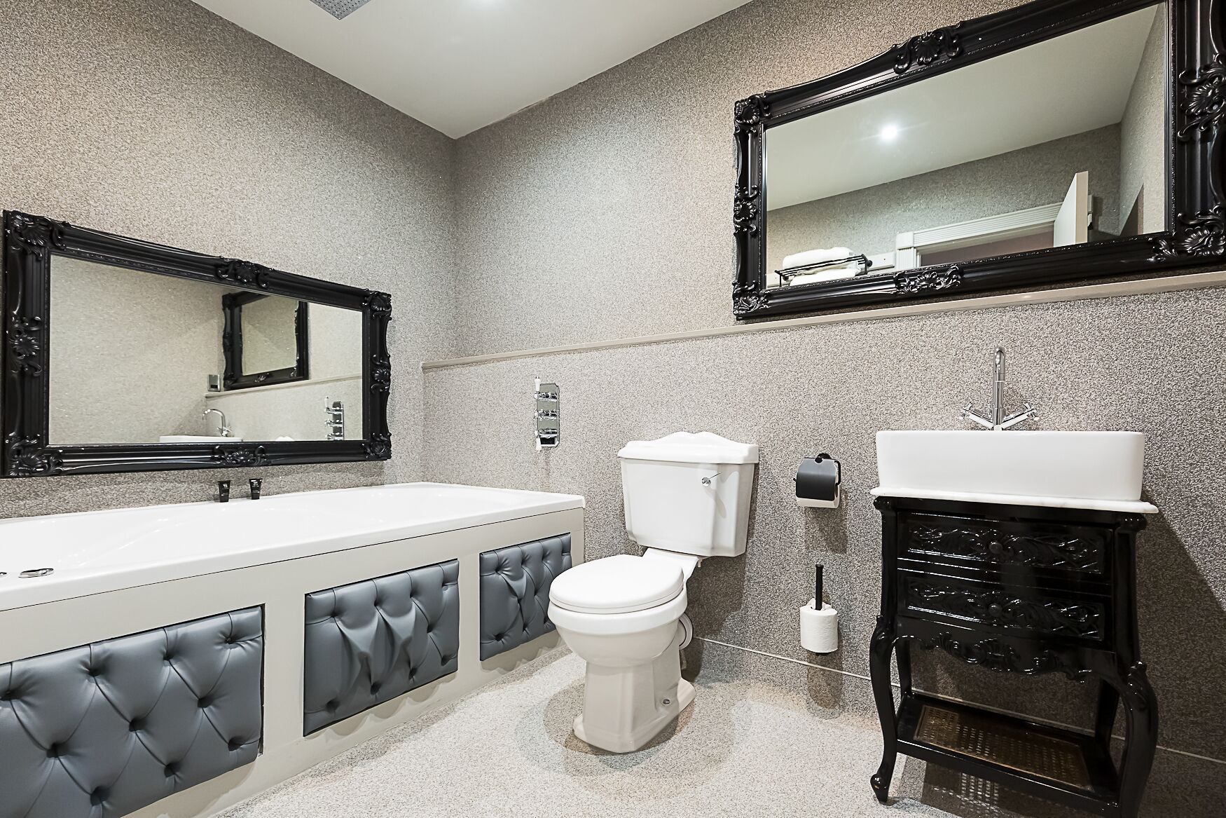 A bathroom with a white sink, a toilet, and a mirror.