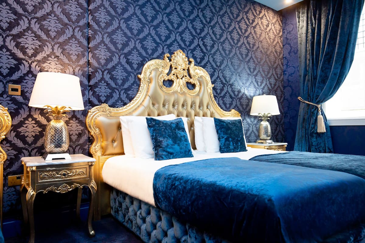 A luxurious bedroom with a large bed, ornate headboard, and matching nightstands.