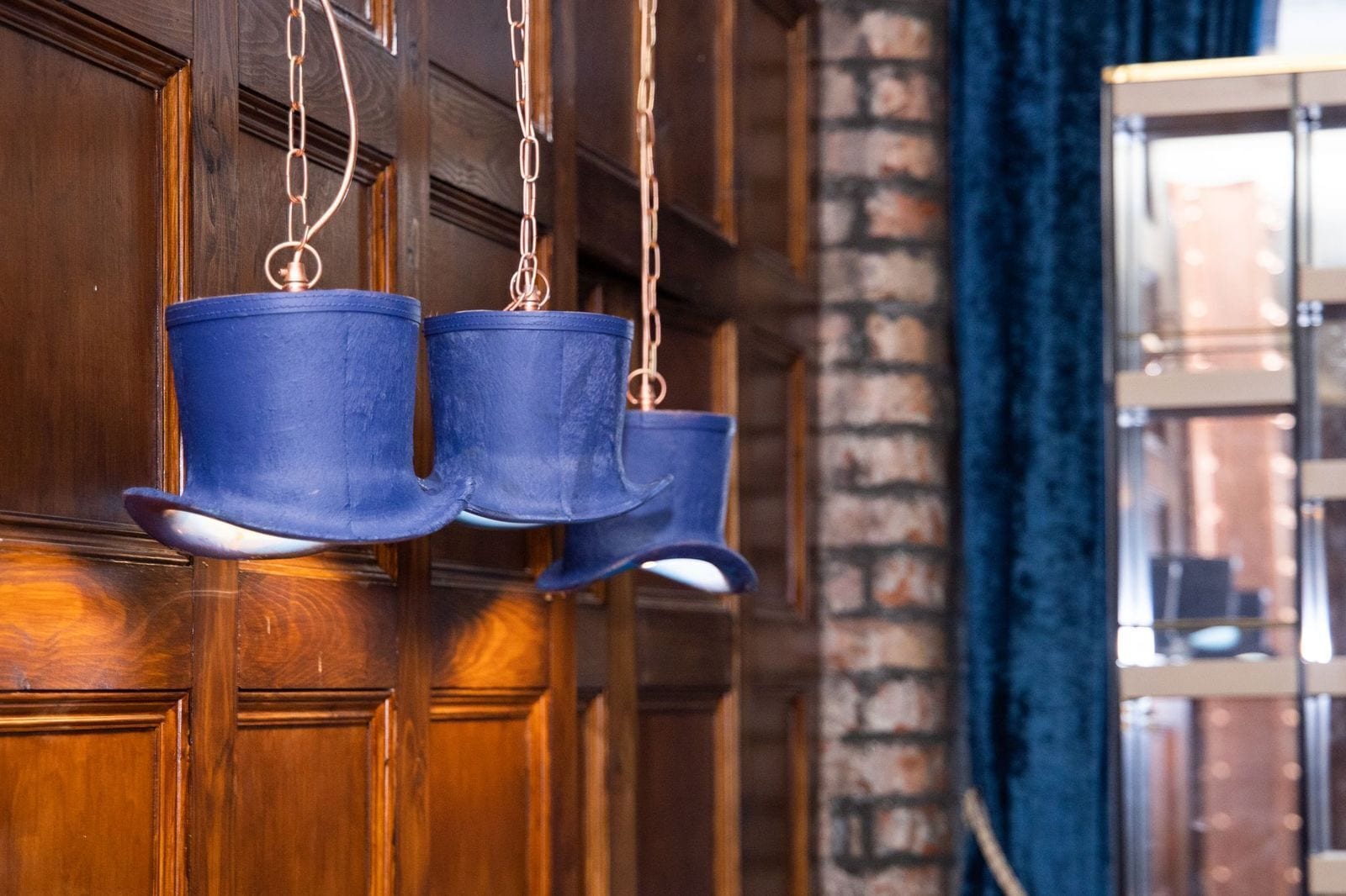 Een houten deur met een metalen ketting en drie blauwe emmers eraan.