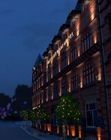 Un edificio in mattoni con insegna illuminata che recita 'The Black Sheep Hotel'.