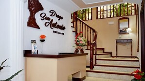 A hotel reception area with a wooden staircase, a reception desk, and a wall sign that reads "San Antonio Hotel." - Hotel Drago San Antonio (Icod de los Vinos)