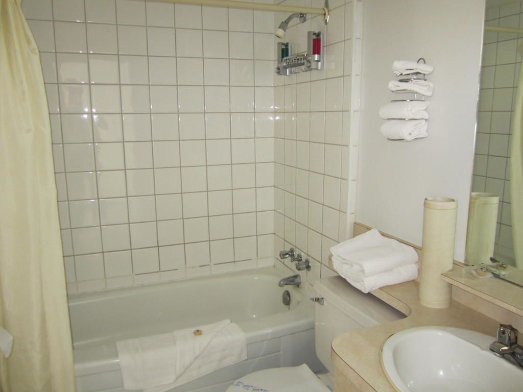 Ein Badezimmer mit einer Badewanne, einem Waschbecken, einem Spiegel und einem Handtuchhalter.