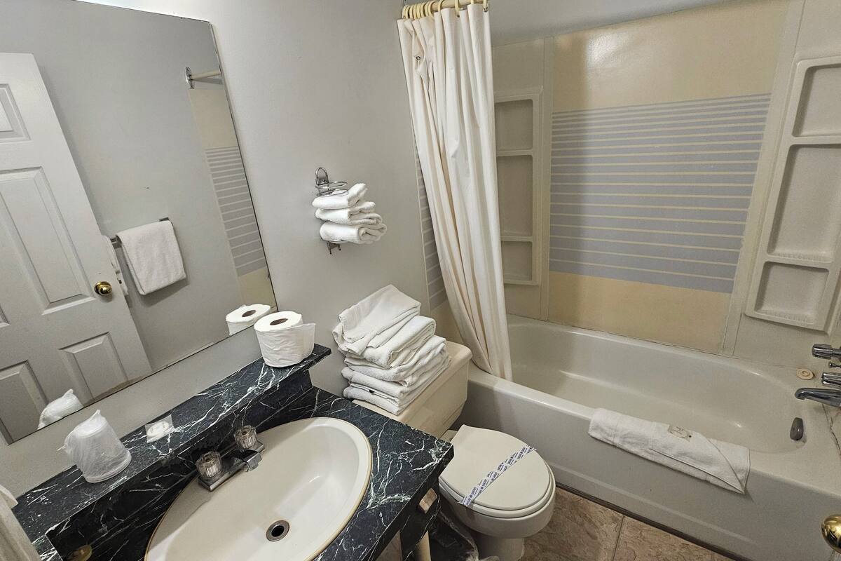 A bathroom with a marble sink, toilet, and bathtub.
