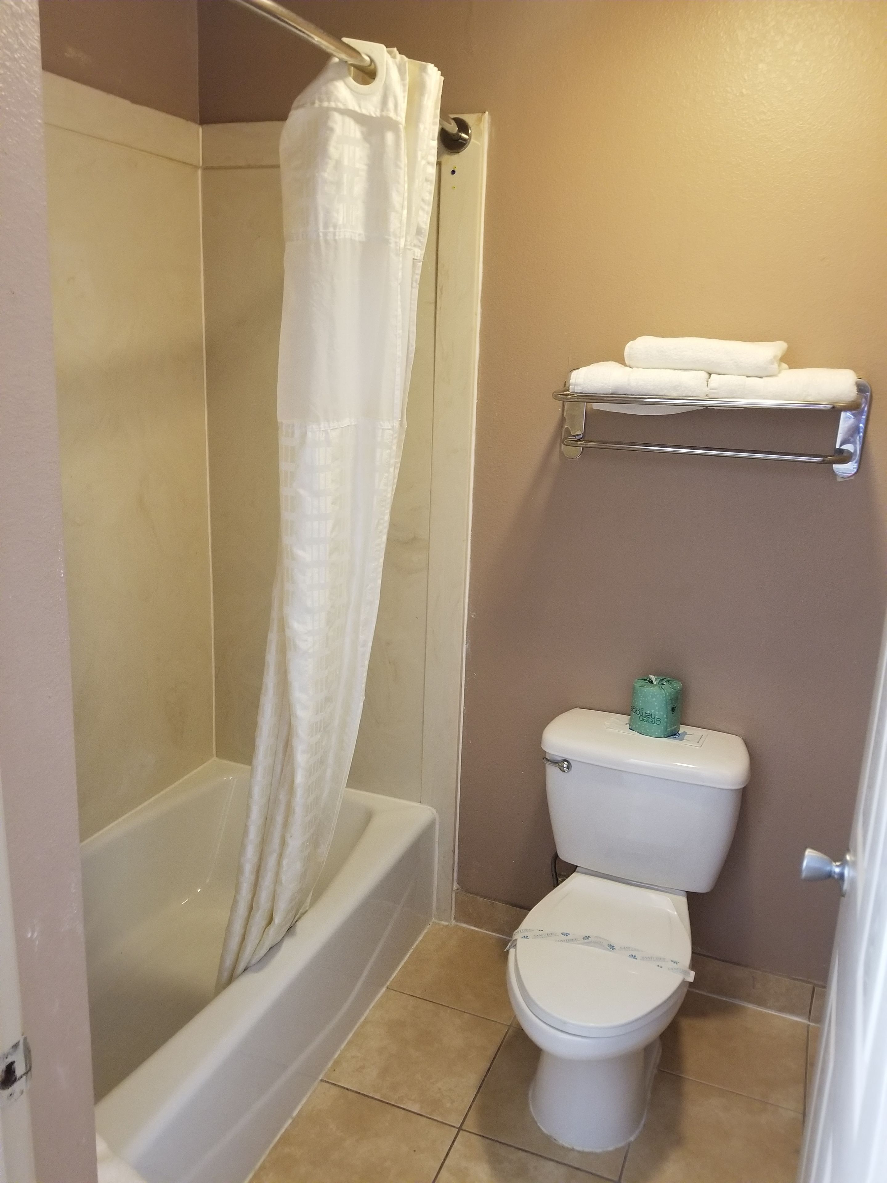Un baño con bañera, inodoro y toallero.
