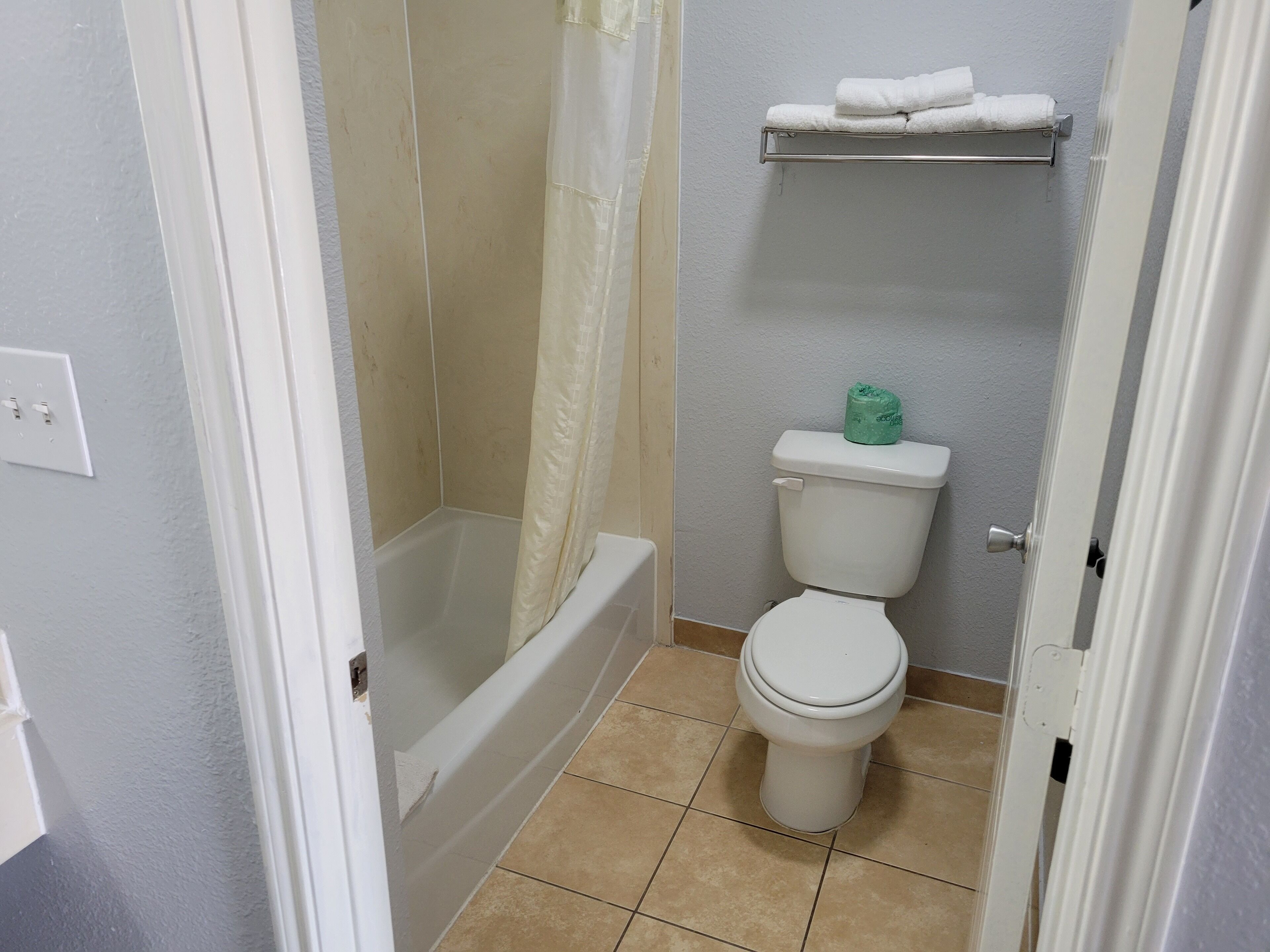 Un baño con bañera, inodoro y barra para toallas.