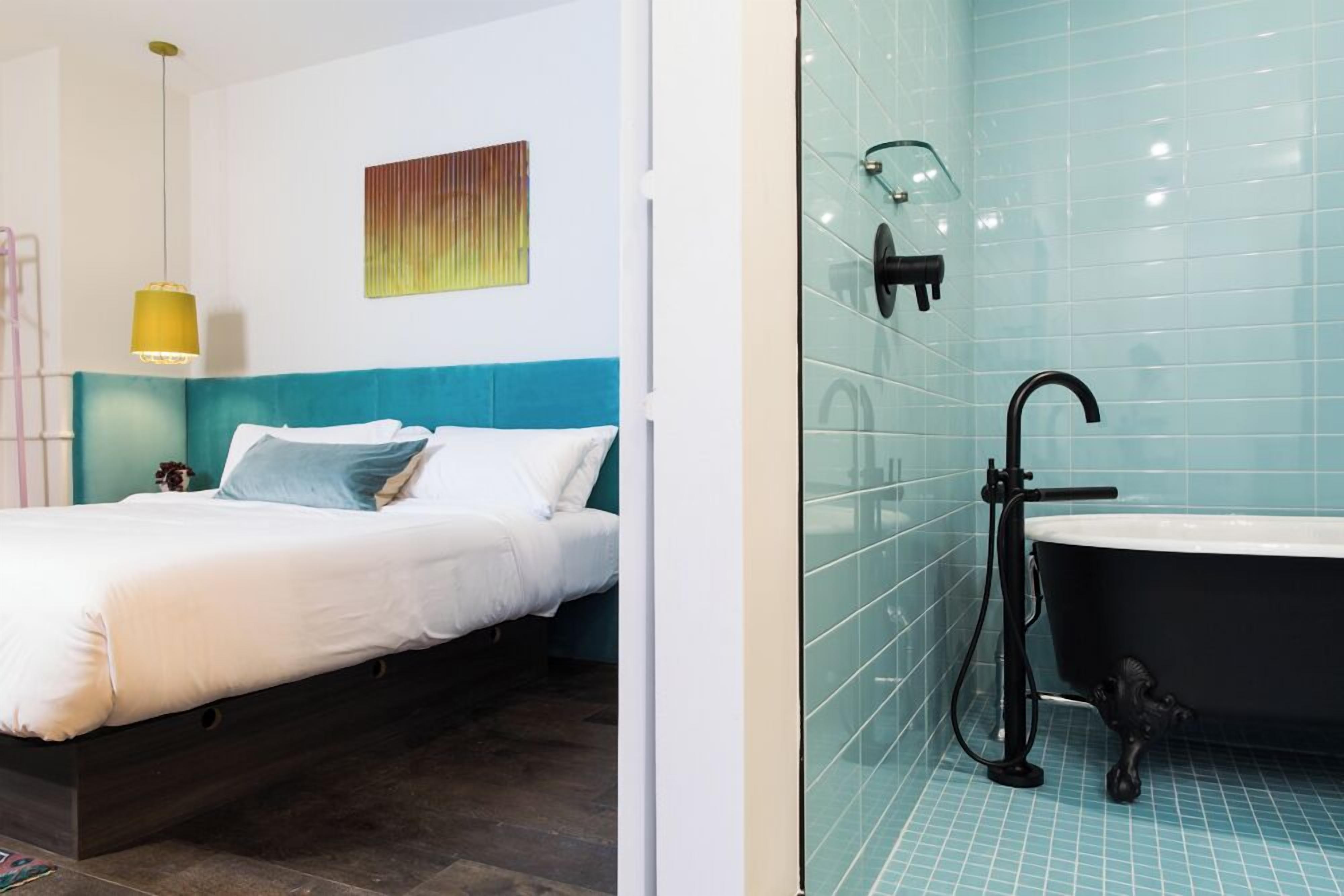 A modern bedroom with a bed, a bedside table, and a nightstand.