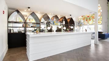 A modern kitchen with a white countertop, decorative vases, and a herringbone wood floor.